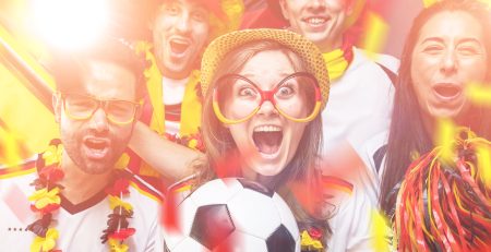 Gruppe glücklicher Fußballfans mit Fanaccessoires jubeln